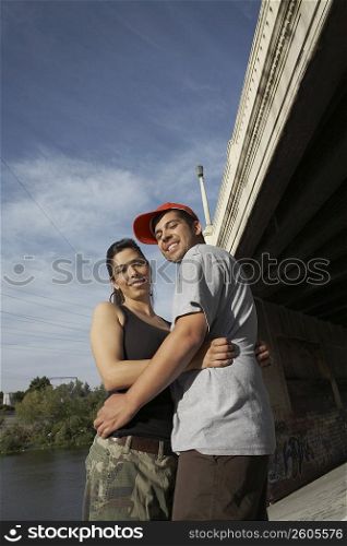 Low angle view of a young couple embracing each other and smiling