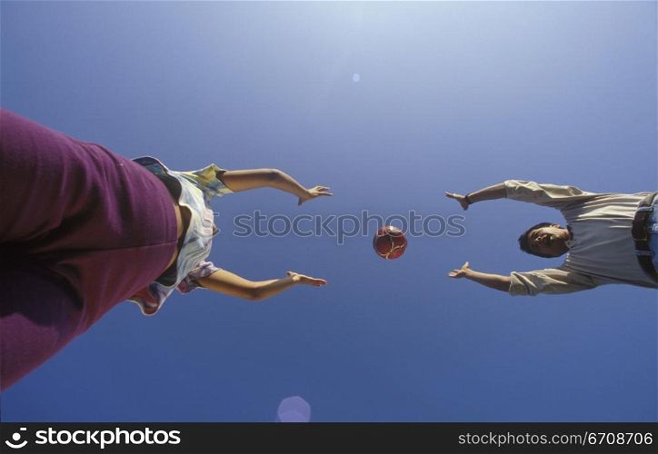 Low angle view of a young couple playing with a ball