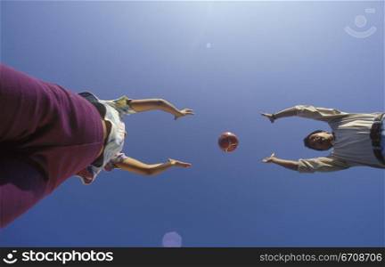 Low angle view of a young couple playing with a ball