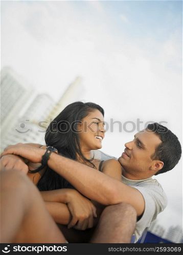 Low angle view of a young couple sitting and looking at each other
