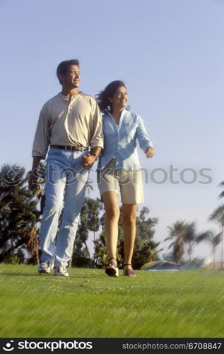 Low angle view of a young couple walking in a park