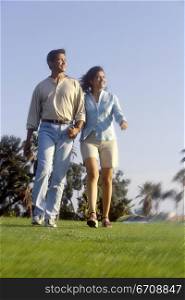 Low angle view of a young couple walking in a park