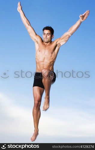 Low angle view of a young man jumping in air