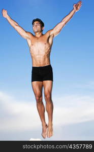 Low angle view of a young man jumping in air