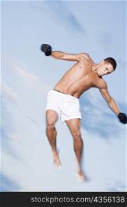 Low angle view of a young man jumping with his arms outstretched