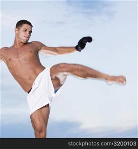 Low angle view of a young man kicking
