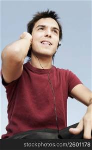 Low angle view of a young man listening to music