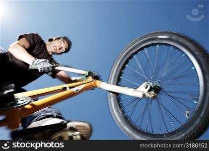 Low angle view of a young man performing a stunt on a bicycle