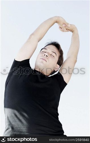 Low angle view of a young man stretching
