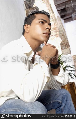 Low angle view of a young man thinking