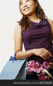 Low angle view of a young woman carrying flowers in a shopping bag