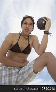 Low angle view of a young woman holding a soccer ball