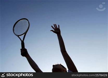 Low angle view of a young woman holding a tennis racket