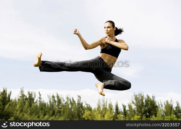 Low angle view of a young woman practicing martial arts