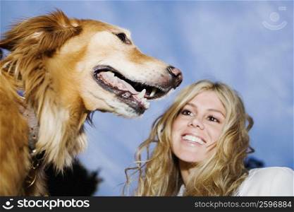Low angle view of a young woman smiling with her dog
