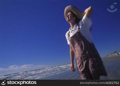 Low angle view of a young woman standing on the beach, Texas, USA