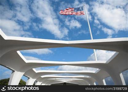 Low angle view of an American flag fluttering on a memorial building, USS Arizona Memorial, Pearl Harbor, Honolulu, Oahu, Hawaii Islands, USA