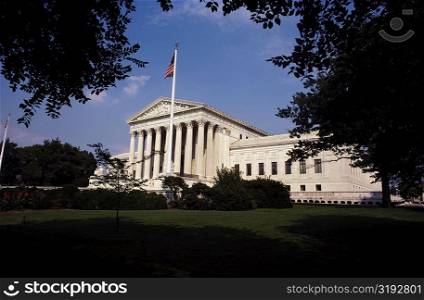 Low angle view of an American flag in front of a government building, US Supreme Court, Washington DC, USA