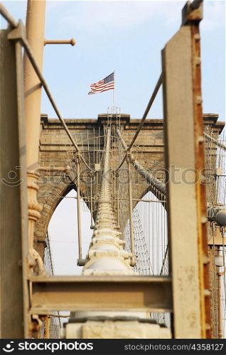 Low angle view of an American flag on a bridge, Brooklyn Bridge, New York City, New York State, USA