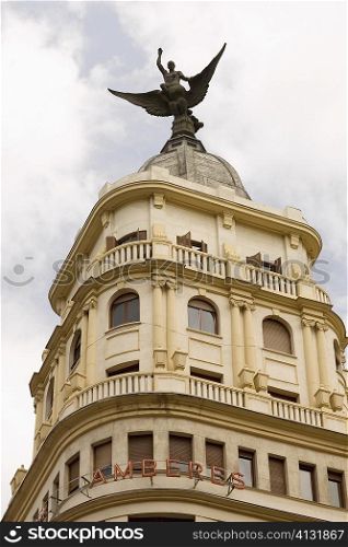 Low angle view of an angel statue on the top of a building, Madrid, Spain