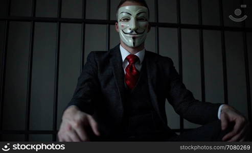Low angle view of Anonymous hacker in prison
