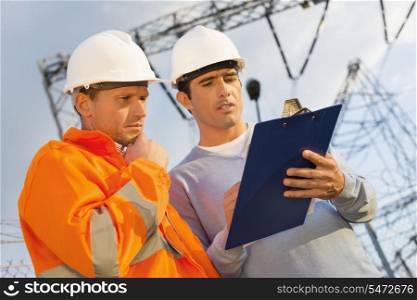 Low angle view of architects discussing over clipboard