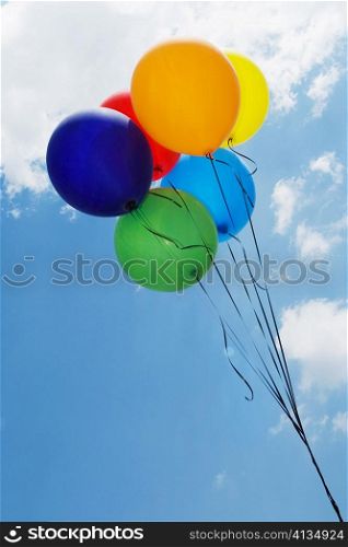 Low angle view of balloons in the sky forming a rainbow flag