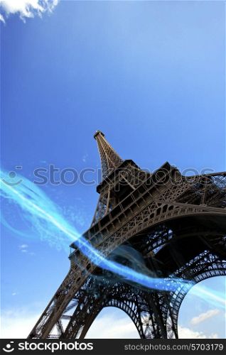 Low angle view of blue streak of lights passing under Eiffel Tower