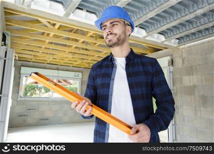 low angle view of builder holding spirit level