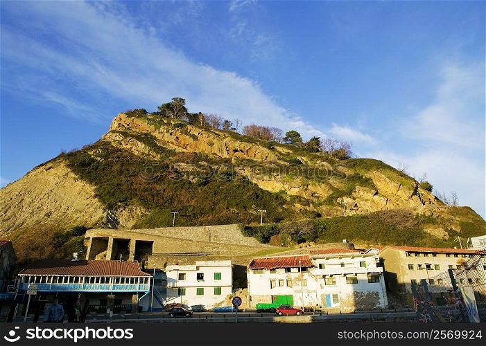 Low angle view of buildings at the foot of a hill, Spain