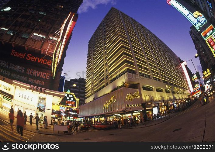 Low angle view of buildings in a city lit up at night, Hong Kong, China