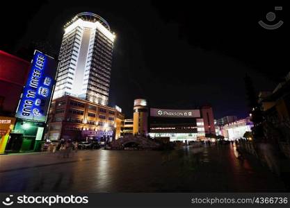 Low angle view of buildings lit up at night, Hefei, Anhui, China