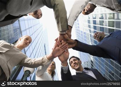 Low angle view of business executives stacking hands