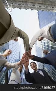 Low angle view of business executives stacking hands