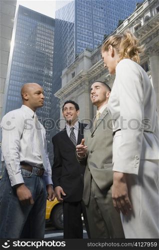 Low angle view of business executives talking with each other and smiling