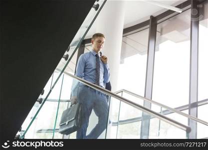 Low angle view of businessman moving down on staircase at office