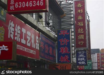 Low angle view of commercial signs on buildings, Beijing, China