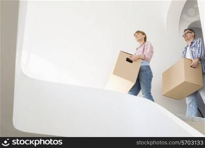 Low angle view of couple with boxes moving into new house
