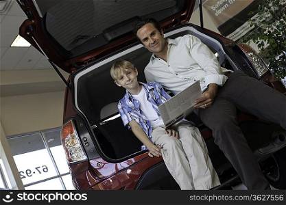 Low angle view of father and son sitting in car