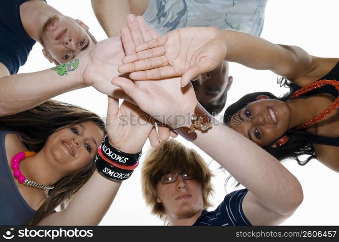 Low angle view of five friends stacking their hands