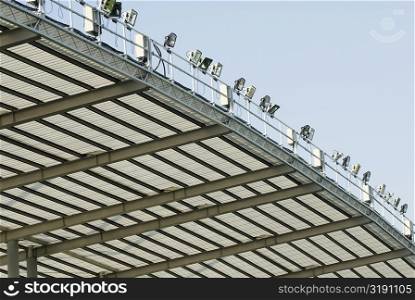 Low angle view of flood lights on a stadium roof
