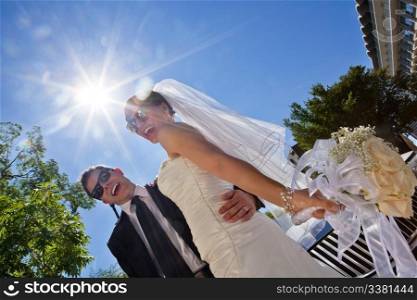Low angle view of happily married couple in sunglasses