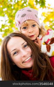 Low angle view of happy smiling family against blurred autumn leaves background