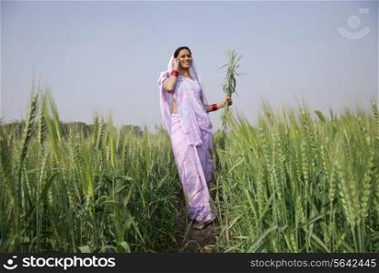 Low angle view of Indian female farm worker talking on mobile phone