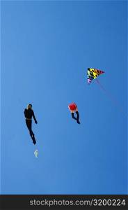 Low angle view of kites flying in the sky