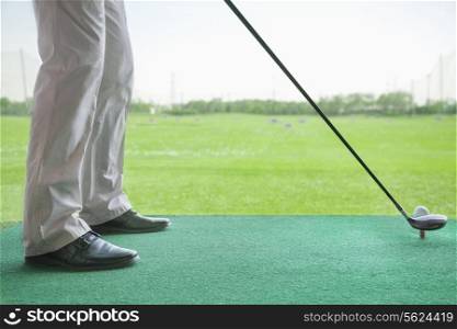 Low angle view of man getting ready to hit a golf ball
