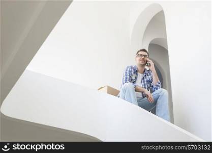 Low angle view of man using cell phone in new home