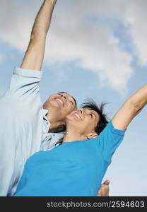 Low angle view of mature couple with their arms raised