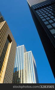 Low angle view of office towers with blue sky.