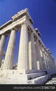 Low angle view of old ruin colonnades in a shrine, Parthenon, Athens, Greece